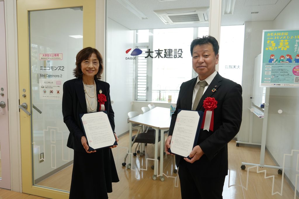 愛称を公募中のミニコモンズ前で
お茶の水女子大学佐々木学長(左)と 当社村尾代表取締役社長(右)